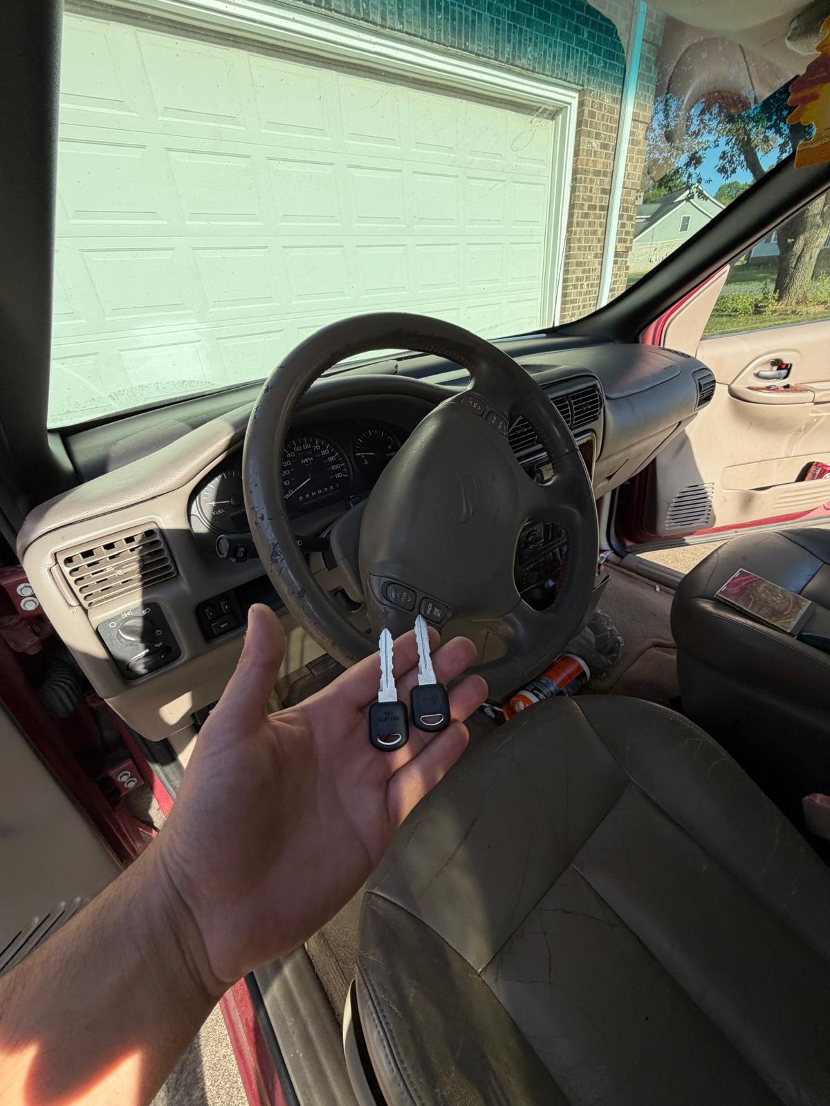 Technician holding newly cut Chevrolet ignition keys inside the vehicle cabin in Charlotte, NC NC