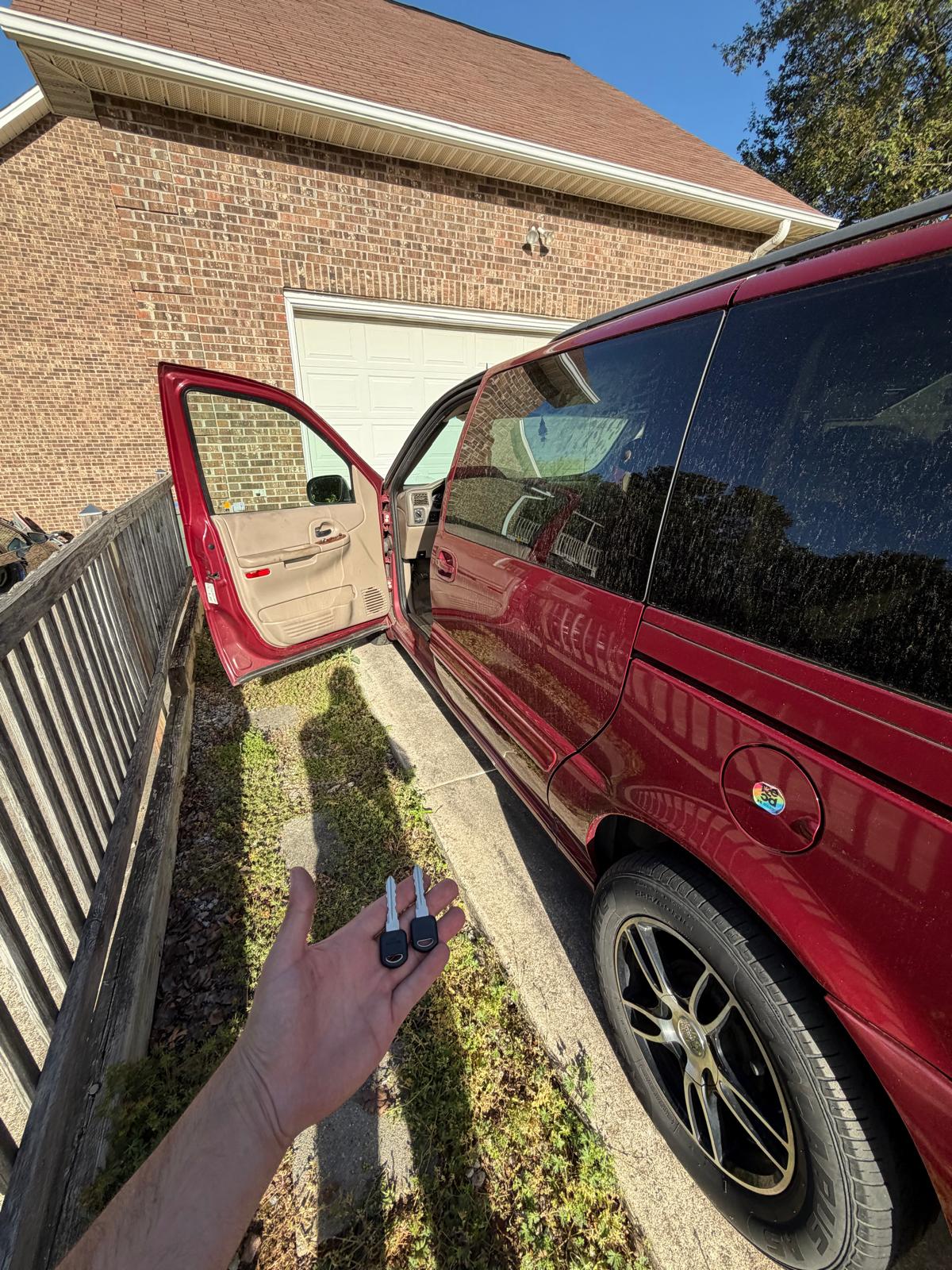 Mobile locksmith holding newly generated Chevrolet transponder keys next to a red Chevy truck in Charlotte, NC NC