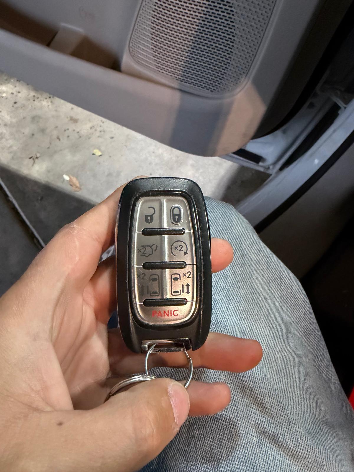 Locksmith holding a fully programmed Chrysler multi-button smart key fob during a custom Locksmith Services job in Charlotte, NC