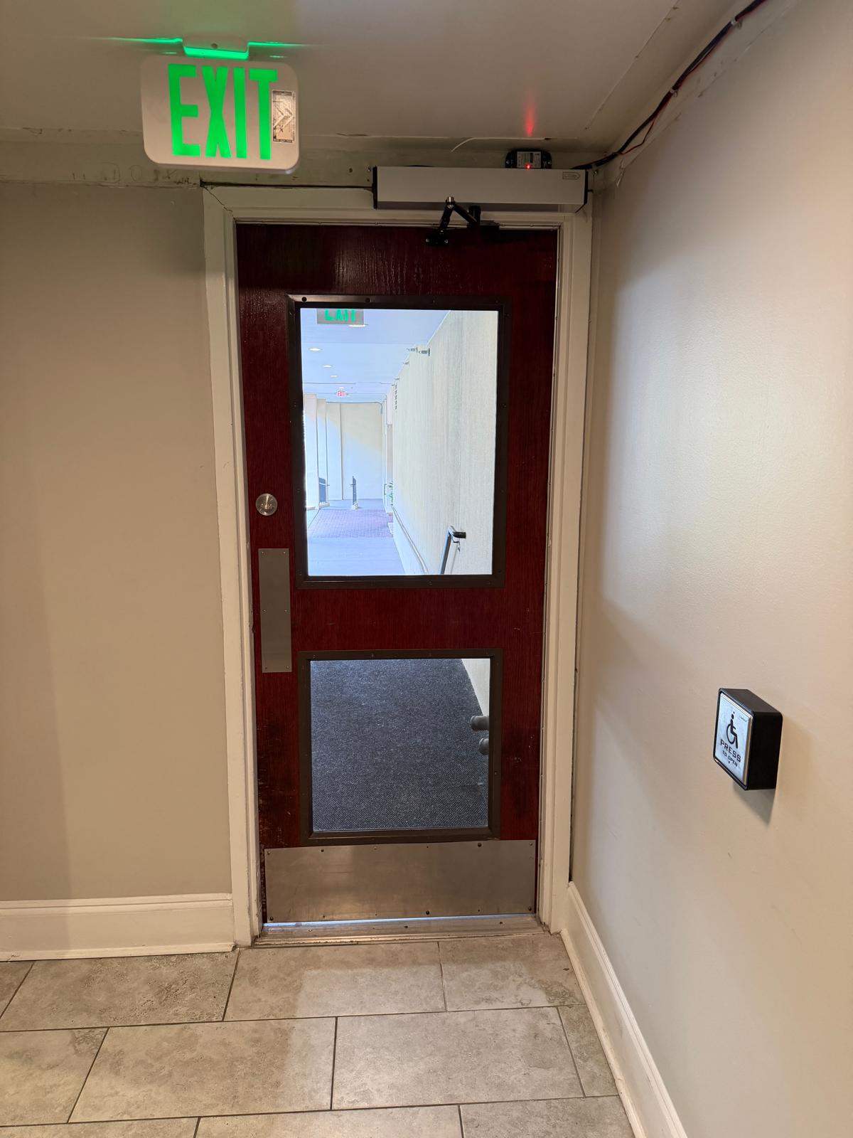 Commercial exit door equipped with emergency panic bar hardware and handicap automatic opener installed by Charlotte Locksmith