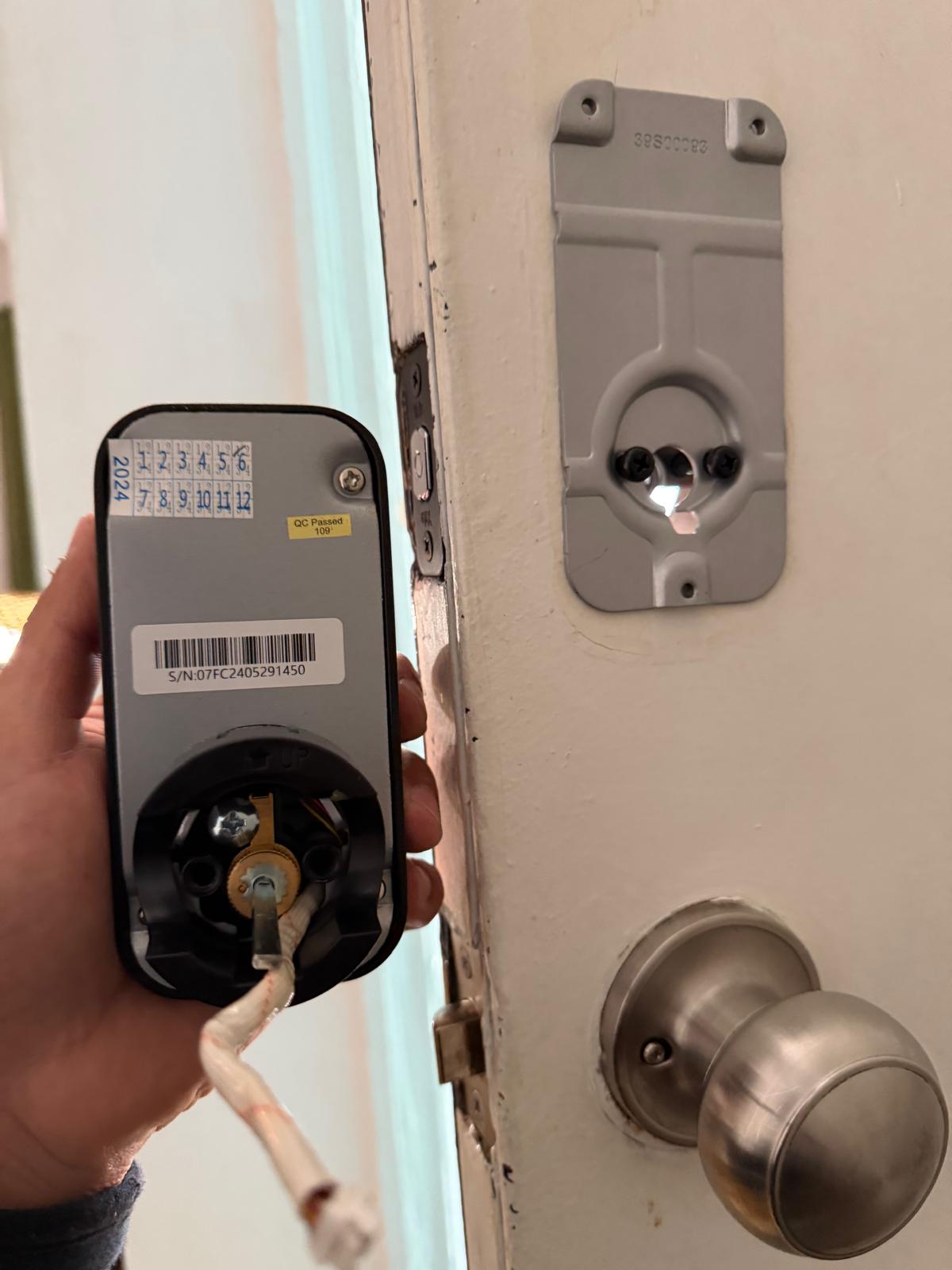 Locksmith installing an electronic smart keypad lock on a wooden residential front door during a custom Electronic Access & Smart Locks job in Charlotte, NC